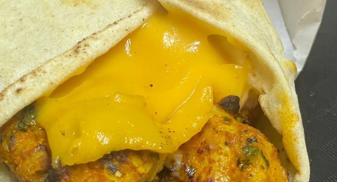 Panini grillé dans son emballage, fromage fondu et poulet épicé